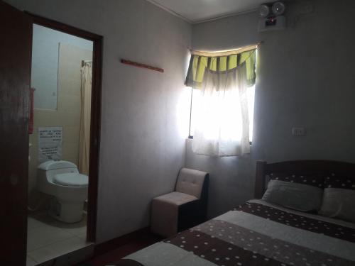 a bedroom with a bed and a toilet and a window at MARANATHA in El Ñuro