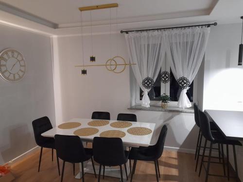 a dining room with a white table and chairs at Apartament Sofia Kowary in Kowary