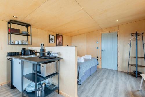 um quarto com uma cozinha e uma cama num quarto em Rustic Cabins, sea views from rewilded farm em St. Andrews