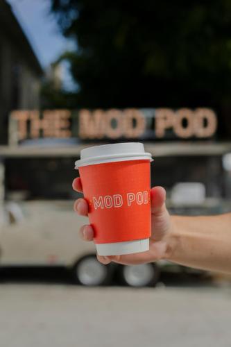 a hand holding a red cup of coffee at Little Mod Hotel at the University in Charlottesville