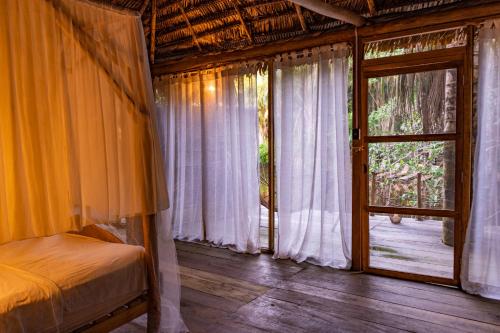 ein Schlafzimmer mit einem Bett und einem großen Fenster in der Unterkunft Aparthotel Ayahuaska for SOLO travelers in Iquitos