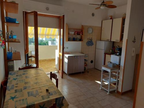 eine Küche mit einem Tisch und eine Küche mit einem Kühlschrank in der Unterkunft Home Mariarita in Montesilvano