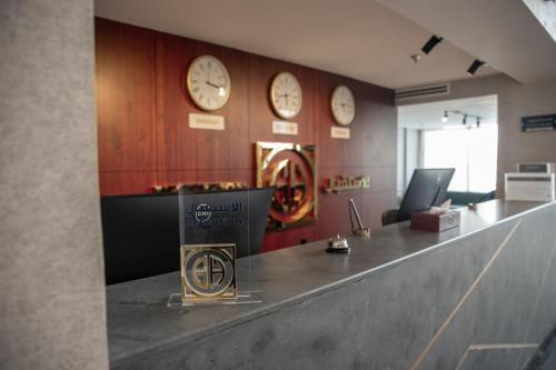 an office with clocks on the wall and a counter at جراند أوتيل للشقق المخدومة Grand Otel Serviced Apartments in Jazan