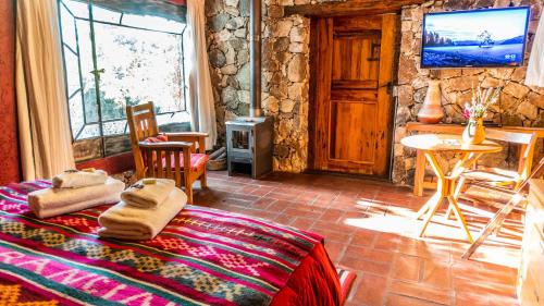 Habitación con cama, TV y mesa. en Araoz de Lamadrid Hotel&Bodega en San Javier