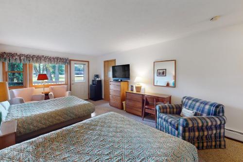 Cette chambre comprend deux lits, une chaise et une télévision. dans l'établissement Golf and Mountain Jewel Bug Studio, à North Woodstock
