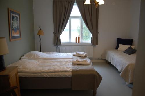 1 dormitorio con 2 camas y ventana en Övermark Bed & Breakfast, 