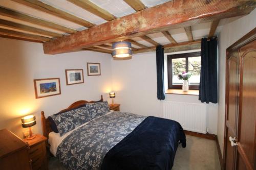 a bedroom with a bed and a window at The Stable, Broughton Beck, near Ulverston in Spark Bridge