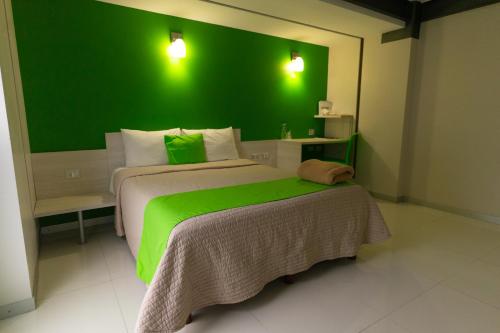 a bedroom with a green wall and a bed at SC HOTEL in Xalapa