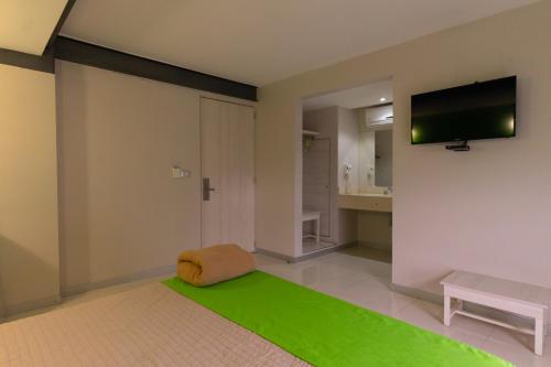 a living room with a green rug and a flat screen tv at SC HOTEL in Xalapa