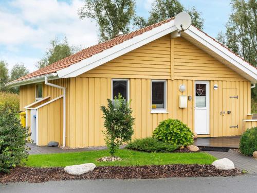 ein gelbes Haus mit weißer Tür in der Unterkunft 4 person holiday home in Otterndorf in Otterndorf
