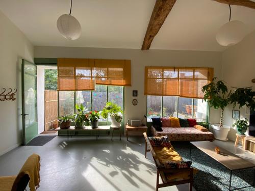 sala de estar con sofá y algunas ventanas en Loft Saint-Jean, en Monségur