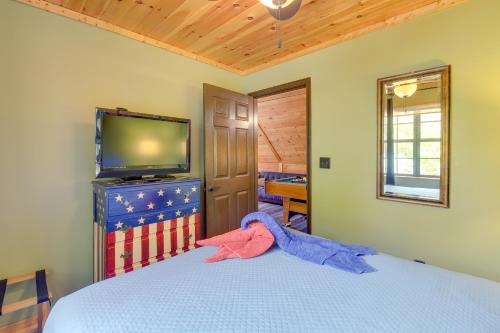 a bedroom with a bed with a tv and an american flag at Above and Beyond Pigeon Forge Cabin with Prime Views! in Pigeon Forge