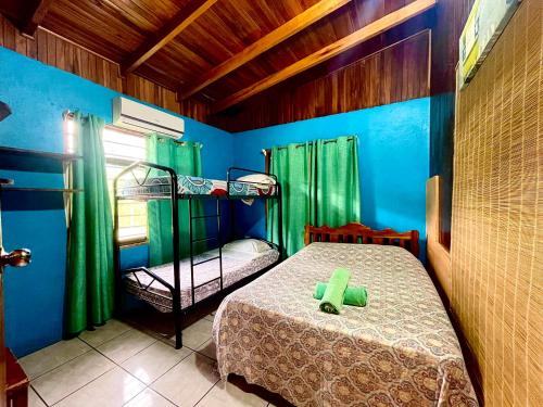 1 Schlafzimmer mit 2 Etagenbetten und grünen Vorhängen in der Unterkunft Pura Natura Lodge Manuel Antonio in Manuel Antonio