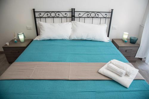 a bed with a blue blanket and a pair of towels on it at Grandis Rooms in Rome