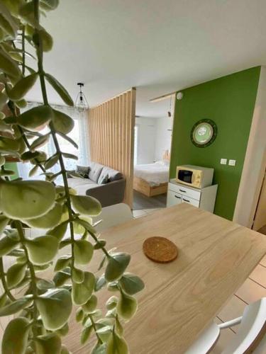 un salon avec une table en bois et une plante dans l'établissement Le porte bonheur, à Vichy