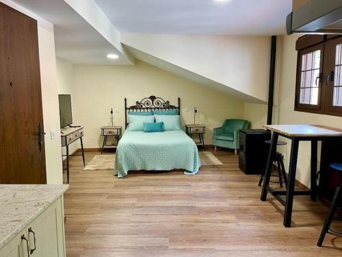 a bedroom with a bed with blue pillows on it at Casina Marqués in Cudillero