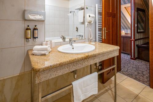 a bathroom with a sink and a bath tub at Hotel Golden Eagle in Levice