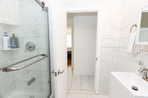 a white bathroom with a shower and a sink at Game Room Near Yale in Hamden