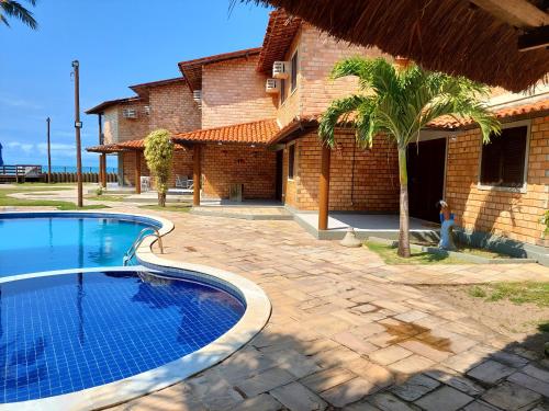 una piscina frente a una casa en Chalé das Conchas, en Maragogi