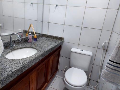 uma casa de banho com um WC branco e um lavatório. em Chalé das Conchas em Maragogi