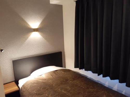 um quarto com uma cama e uma luz na parede em ＨＯＴＥＬ ＷＩＮ - Vacation STAY 72249v em Imari