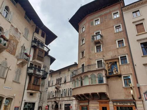 a tall building with windows and balconies on a street at Monolocale Mati - Holiday Home in Trento