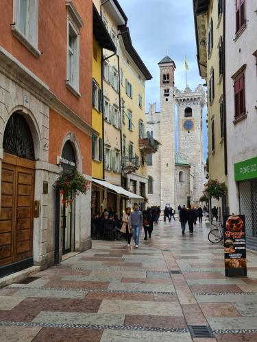a group of people walking down a street with buildings at Monolocale Mati - Holiday Home in Trento