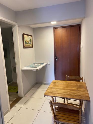 Habitación con mesa y puerta de madera. en Apartamento Formosa 155, en Cabo Frío