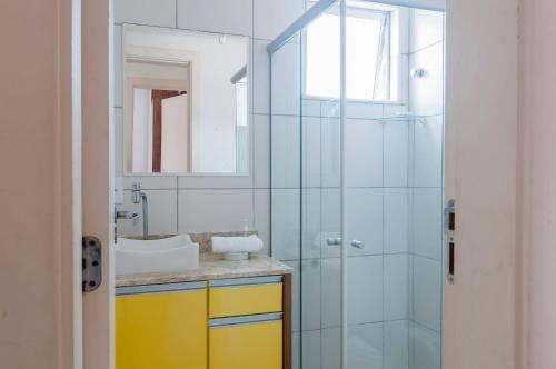 uma casa de banho com uma cabina de duche em vidro e um lavatório. em Apto em cond c piscina a 2min da praia VJG301 em Ilhéus
