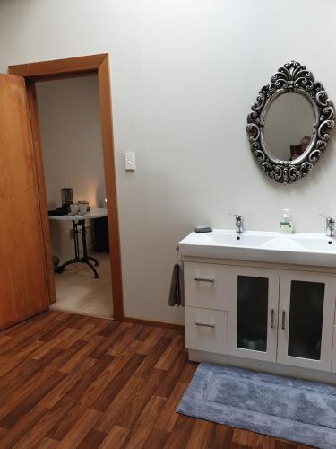 łazienka z umywalką i lustrem na ścianie w obiekcie Royal Accommodation w mieście Stratford