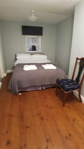 a bedroom with a large bed and a chair at Puffin Place,Lloyd House in Haverfordwest