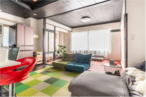 ein Wohnzimmer mit einem Sofa und einem roten Stuhl in der Unterkunft Little Okawood - Vacation STAY 83117v in Ōkawa