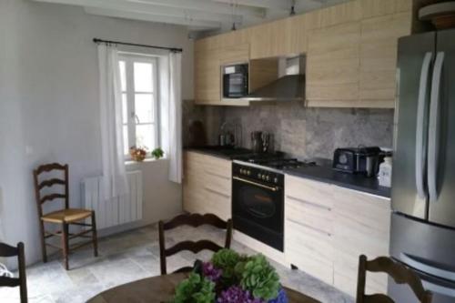 uma cozinha com uma mesa, um fogão e um frigorífico em Bright house with garden - île de Ré em Saint-Clément-des-Baleines