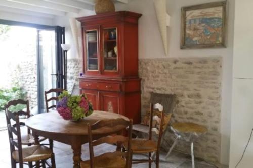 uma sala de jantar com uma mesa e um armário em Bright house with garden - île de Ré em Saint-Clément-des-Baleines