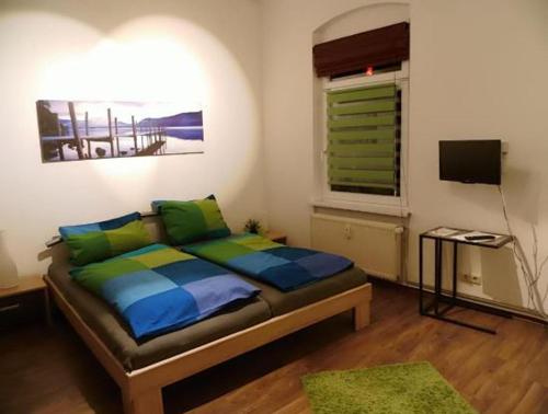 a bedroom with a bed and a window and a television at Kleine Apartments in Torgau