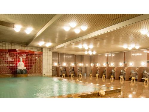 una piscina in una stanza con sedie e tavolo di Yamashiro Onsen Yuzankaku - Vacation STAY 86432v a Kaga