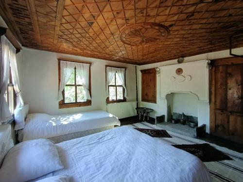 a bedroom with two beds and a fireplace at Hacı Şakirler Konağı in Mudurnu