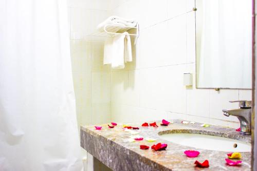 a bathroom with a sink with roses on the counter at Hotel Nouzha in Fès