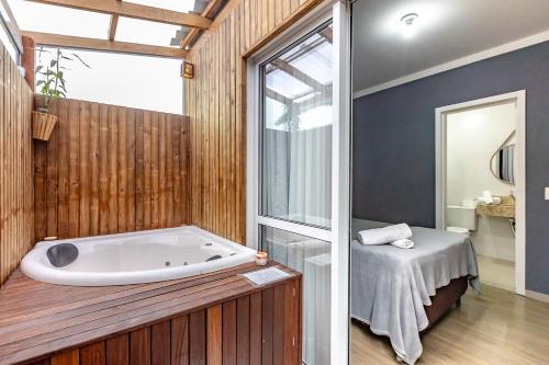 Apartamento 2 quartos com Spá Expocentro Praias في باليريو كامبوريو: حمام مع حوض استحمام ونافذة