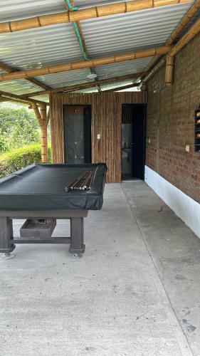 a ping pong table sitting under a covered patio at Hotel Campestre La María Toro Valle in Toro