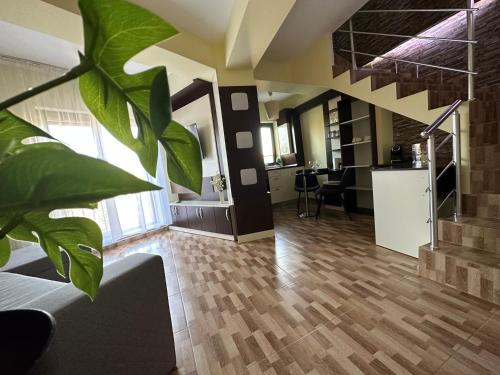 a living room with a plant and a staircase at XOX Comfort Giurgiului in Bucharest