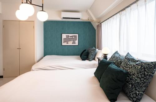 a bedroom with two beds and a green wall at Princet Shinjuku Building - Vacation STAY 15549 in Tokyo
