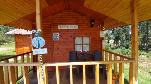 una cabaña con reloj en el porche en Cabaña campestre #1 en Ráquira
