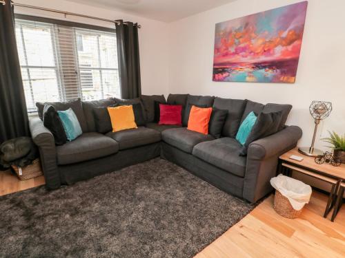 a living room with a gray couch with colorful pillows at Lavenna in Alnwick