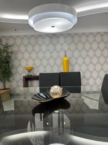 a dining room with a glass table and a lamp at APARTAMENTO EM EDIFICIO 100% MOBILIADO PARA TEMPORADA in Manaus