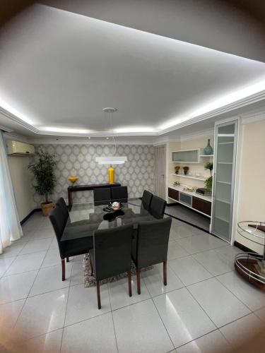 a living room with a table and chairs and a room at APARTAMENTO EM EDIFICIO 100% MOBILIADO PARA TEMPORADA in Manaus