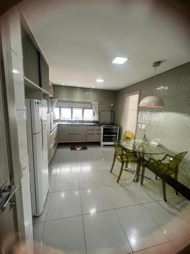 a kitchen with a table and a kitchen with a refrigerator at APARTAMENTO EM EDIFICIO 100% MOBILIADO PARA TEMPORADA in Manaus