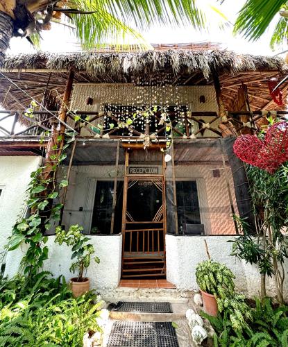 a house with a wooden door in front of it at Sirenas Caribbean Rooms Holbox in Holbox Island