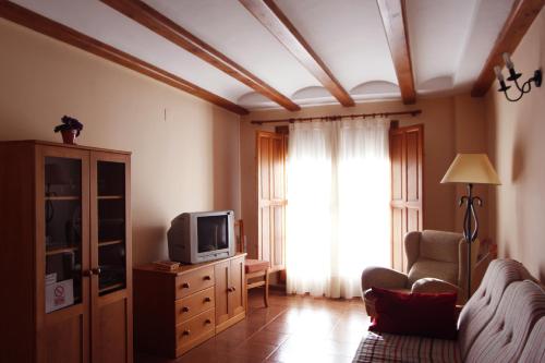 ein Wohnzimmer mit einem Sofa und einem TV in der Unterkunft Casa 1340 in Mora de Rubielos