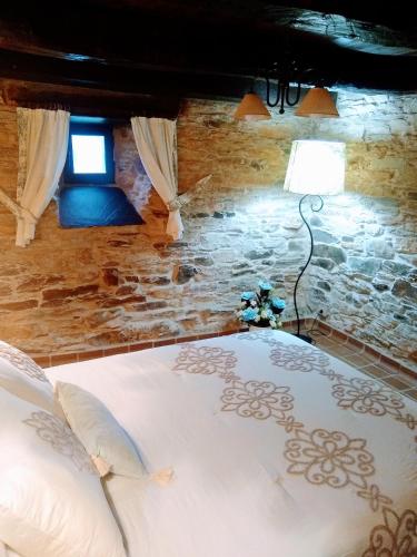 a bedroom with a bed and a lamp and a window at Casa Pacios by M de Santiago in Tríacastela